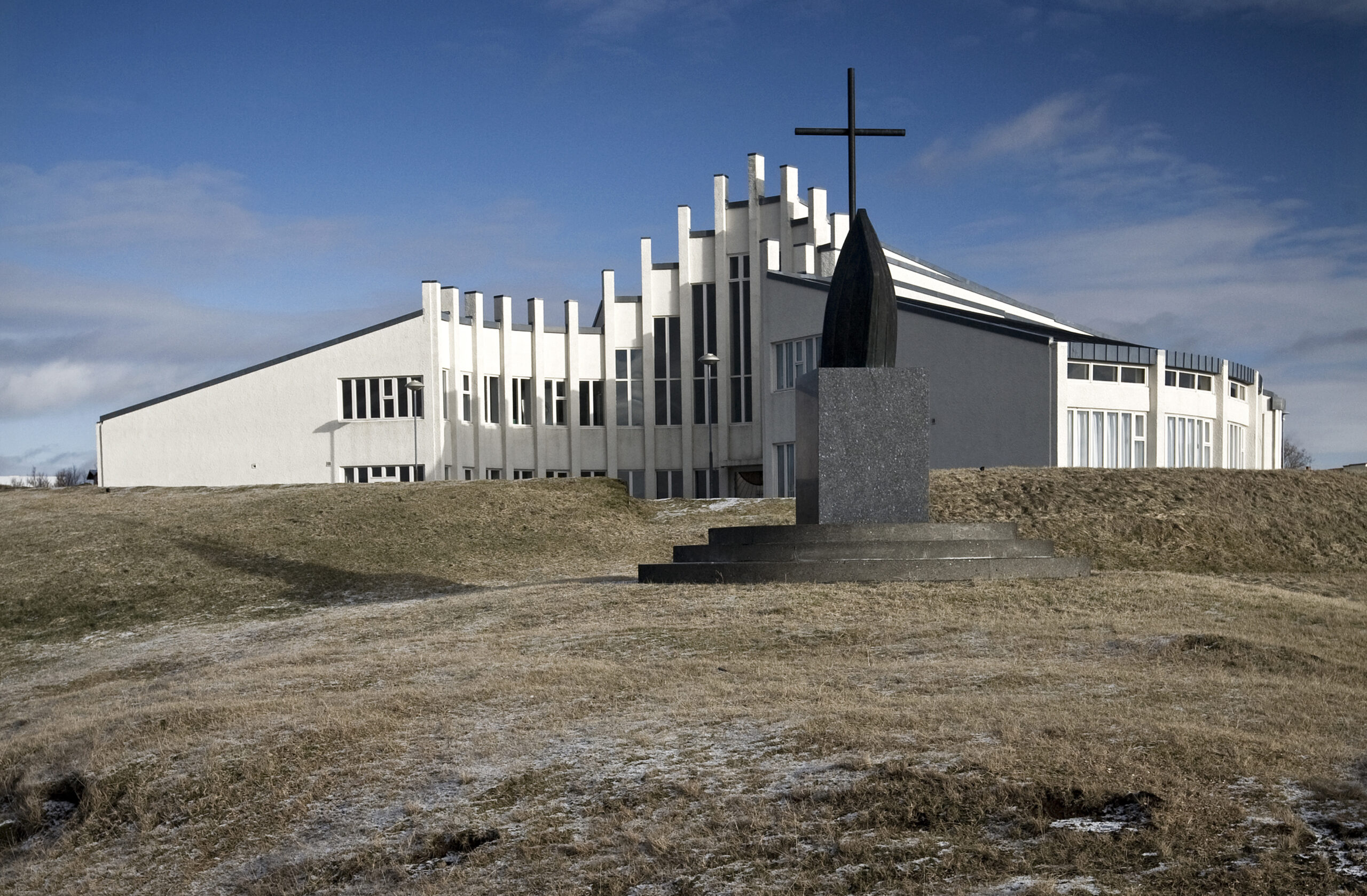 Víðistaðakirkja séð að framan í sólskini.
